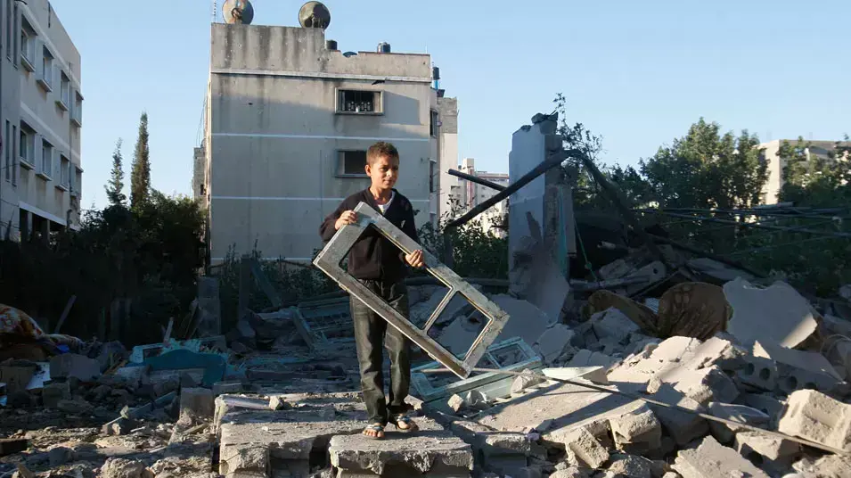 ילד פלשתיני מחזיק חלון אחרי תקיפה של חיל האוויר במהלך מבצע עמוד ענן