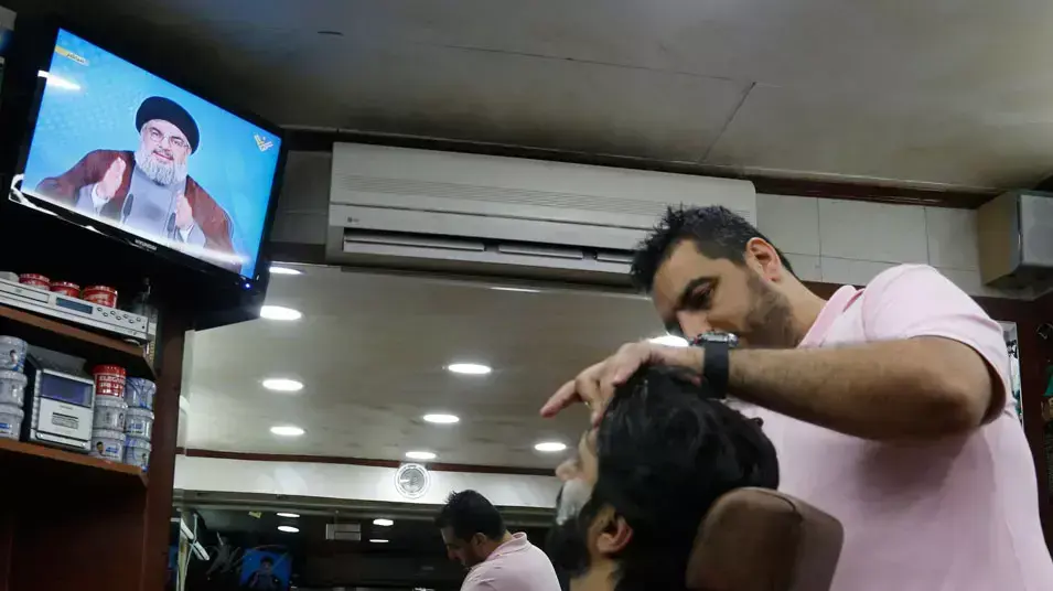 שידור נאומו של חסן נסראללה במספרה בביירות, לבנון. אפריל 2013 שידור נאומו של חסן נסראללה במספרה בביירות, לבנון. אפריל 2013