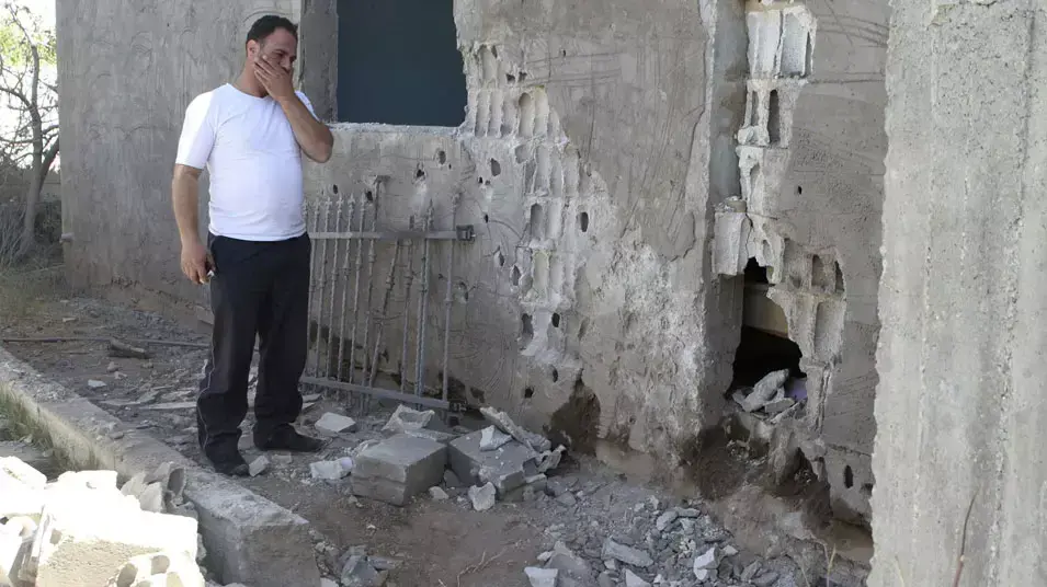 תושב בעלבכ בלבנון לידי ביתו שנהרס מפגיעת רקטה, יוני 2013