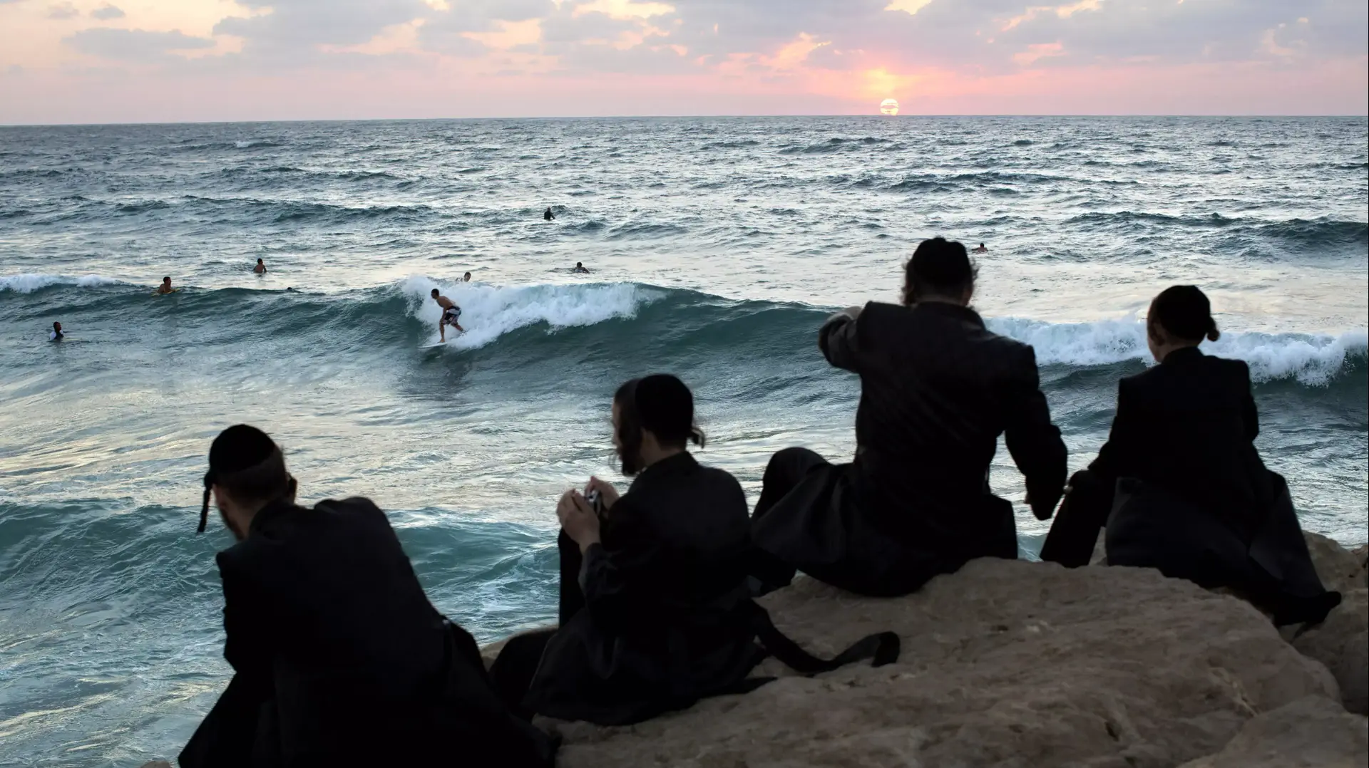 חרדים מביטים בגולשים בים באשדוד, ספטמבר 2013