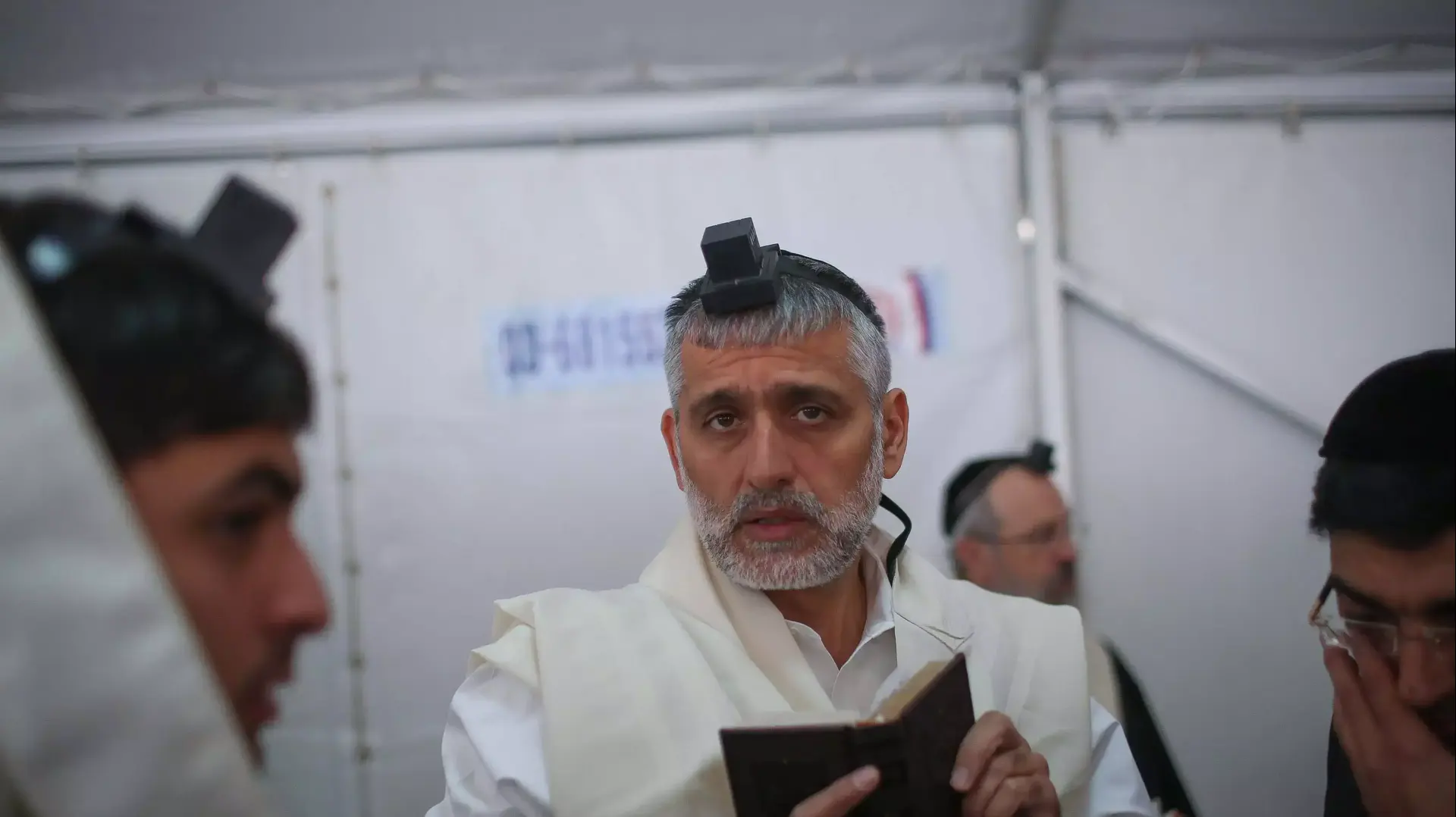 אלי ישי מניח תפילין בסוכת האבלים בבית משפחת יוסף, אוקטובר 2013 אלי ישי מניח תפילין בסוכת האבלים בבית משפחת יוסף, אוקטובר 2013