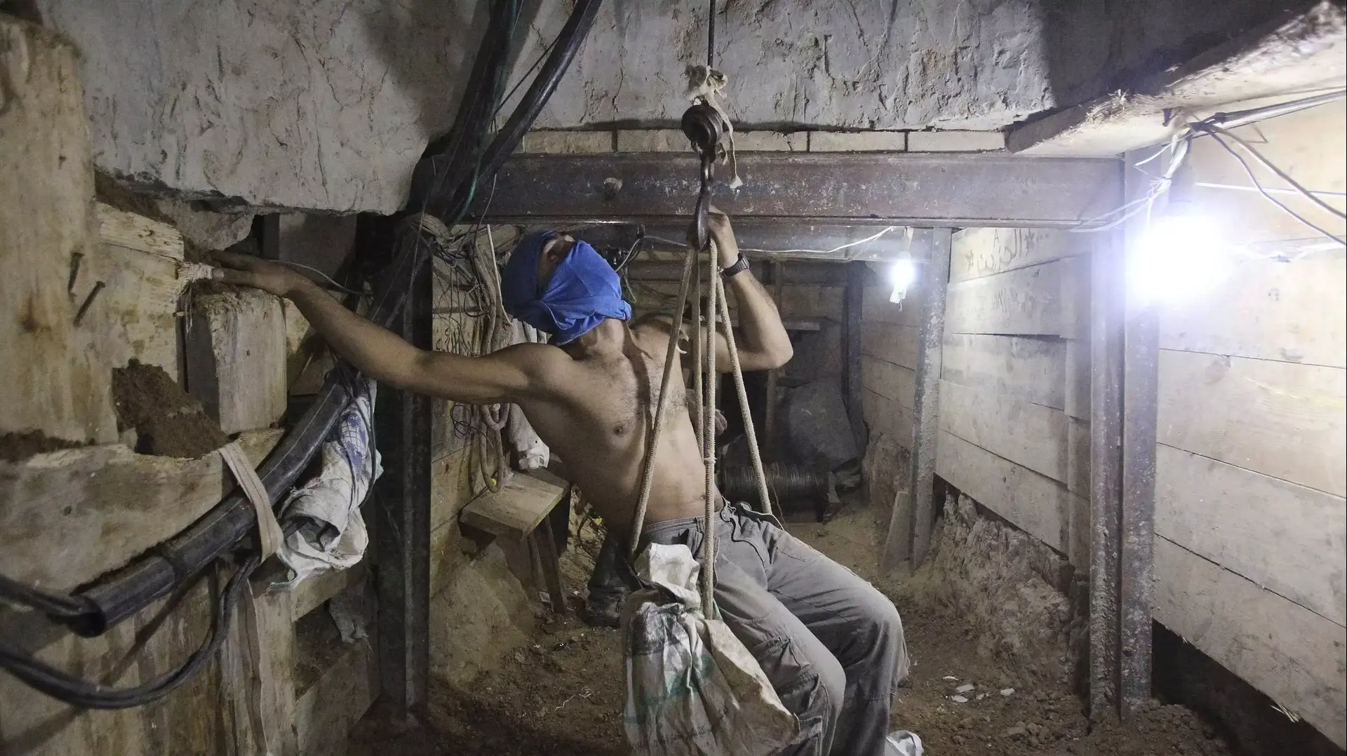 פלסטיני רעול פנים בתוך מנהרת הברחה בגבול בין מצרים לרצועת עזה, אוקטובר 2013 פלסטיני רעול פנים בתוך מנהרת הברחה בגבול בין מצרים לרצועת עזה, אוקטובר 2013