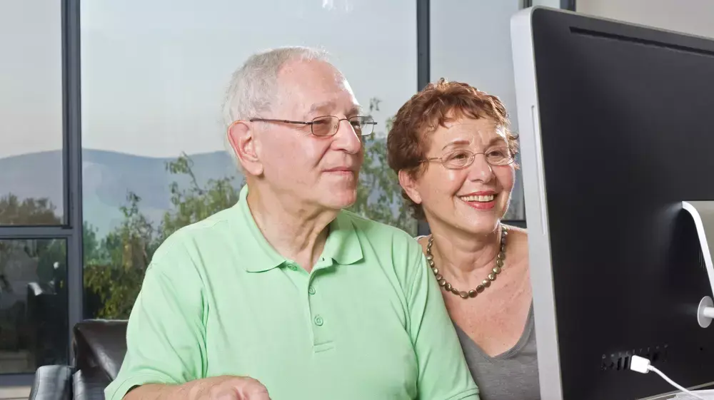זוג מבוגרים יושבים מול מחשב זוג מבוגרים יושבים מול מחשב