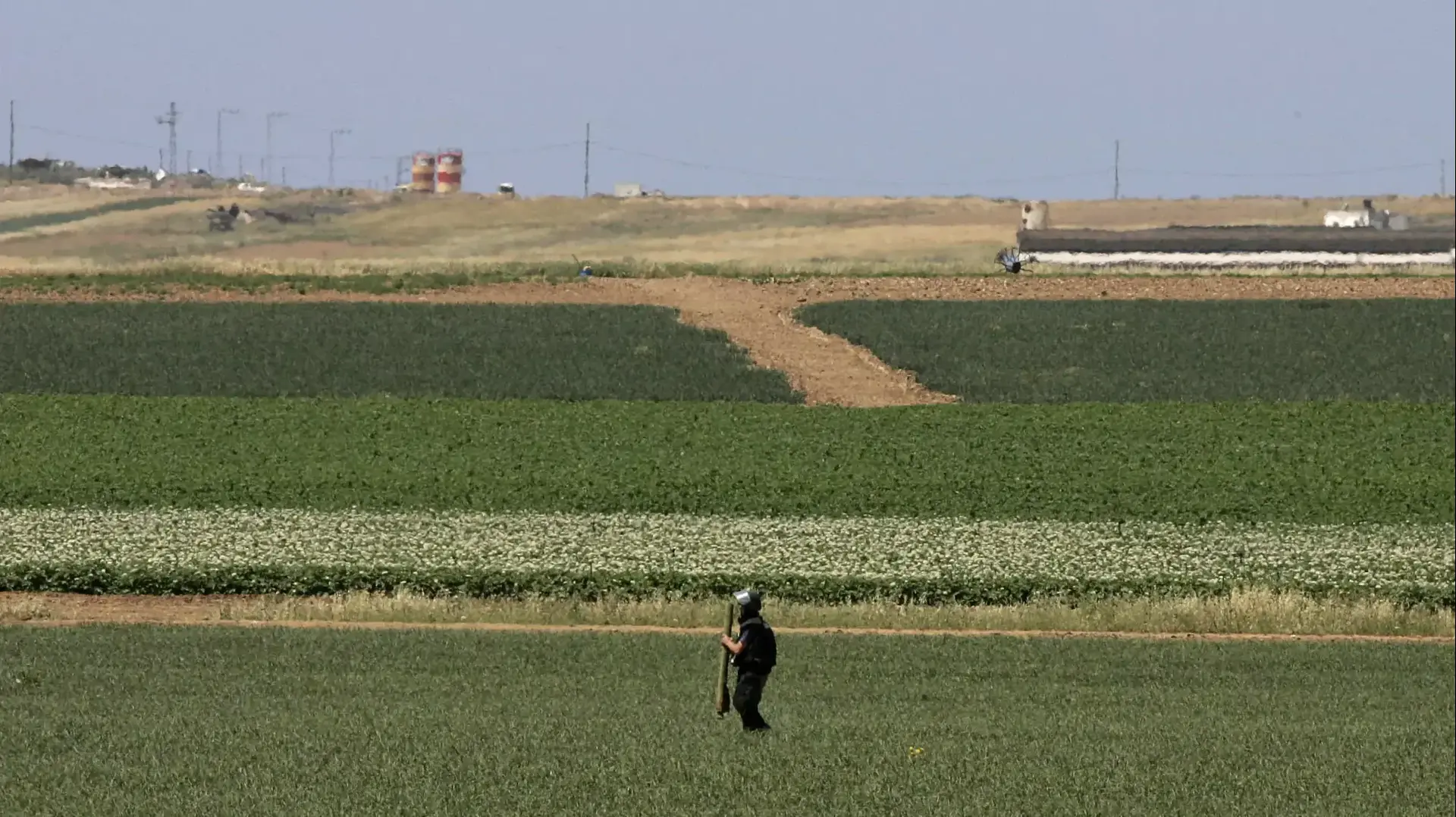 איש כוחות הביטחון מחזיק שרידי רקטה בשדות ליד קיבוץ נחל עוז, 2008 איש כוחות הביטחון מחזיק שרידי רקטה בשדות ליד קיבוץ נחל עוז, 2008
