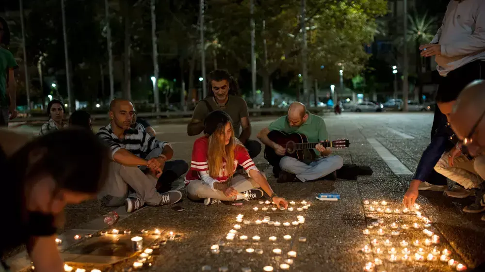 אזרחים מדליקים נרות לאריק איינשטיין בכיכר רבין, נובמבר 2013