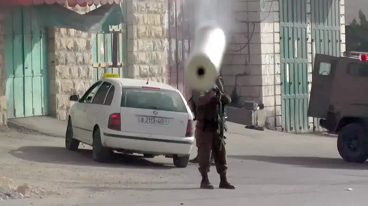 חייל יורה רימון גז ישירות על מתנדב בצלם חייל יורה רימון גז ישירות על מתנדב בצלם