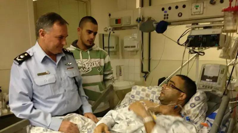 המפכ"ל יוחנן דנינו בביקור אצל השוטר שנדקר, רמי רביד, בביה"ח שערי צדק בירושלים. דצמבר 2013