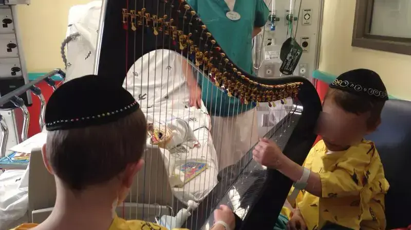 הילדים מיכאל ויצחק גרוס מאסון ההרעלה מנגנים בנבל בבית חולים שניידר הילדים מיכאל ויצחק גרוס מאסון ההרעלה מנגנים בנבל בבית חולים שניידר