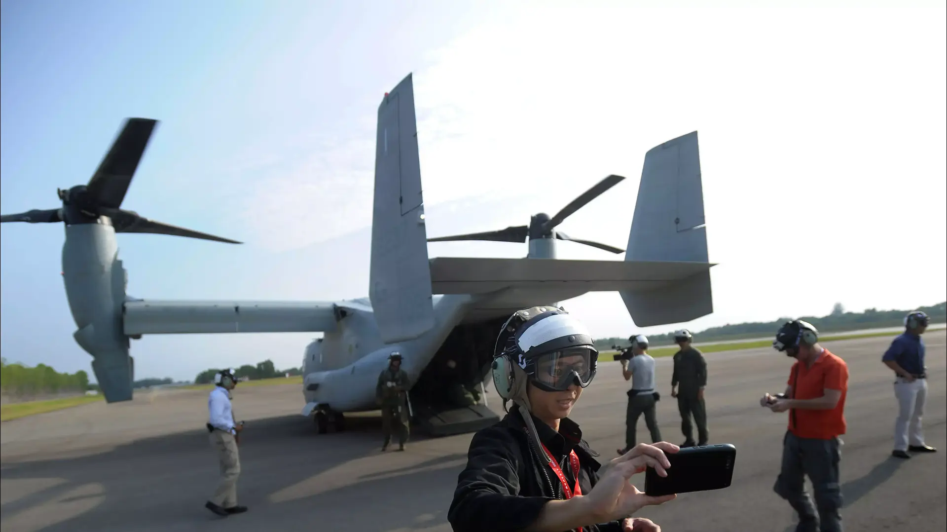 עיתונאית מצלמת סלפי ליד מסוק V-22 של חיל הנחתים האמריקני, ביריד האווירי של סינגפור. פברואר 2014