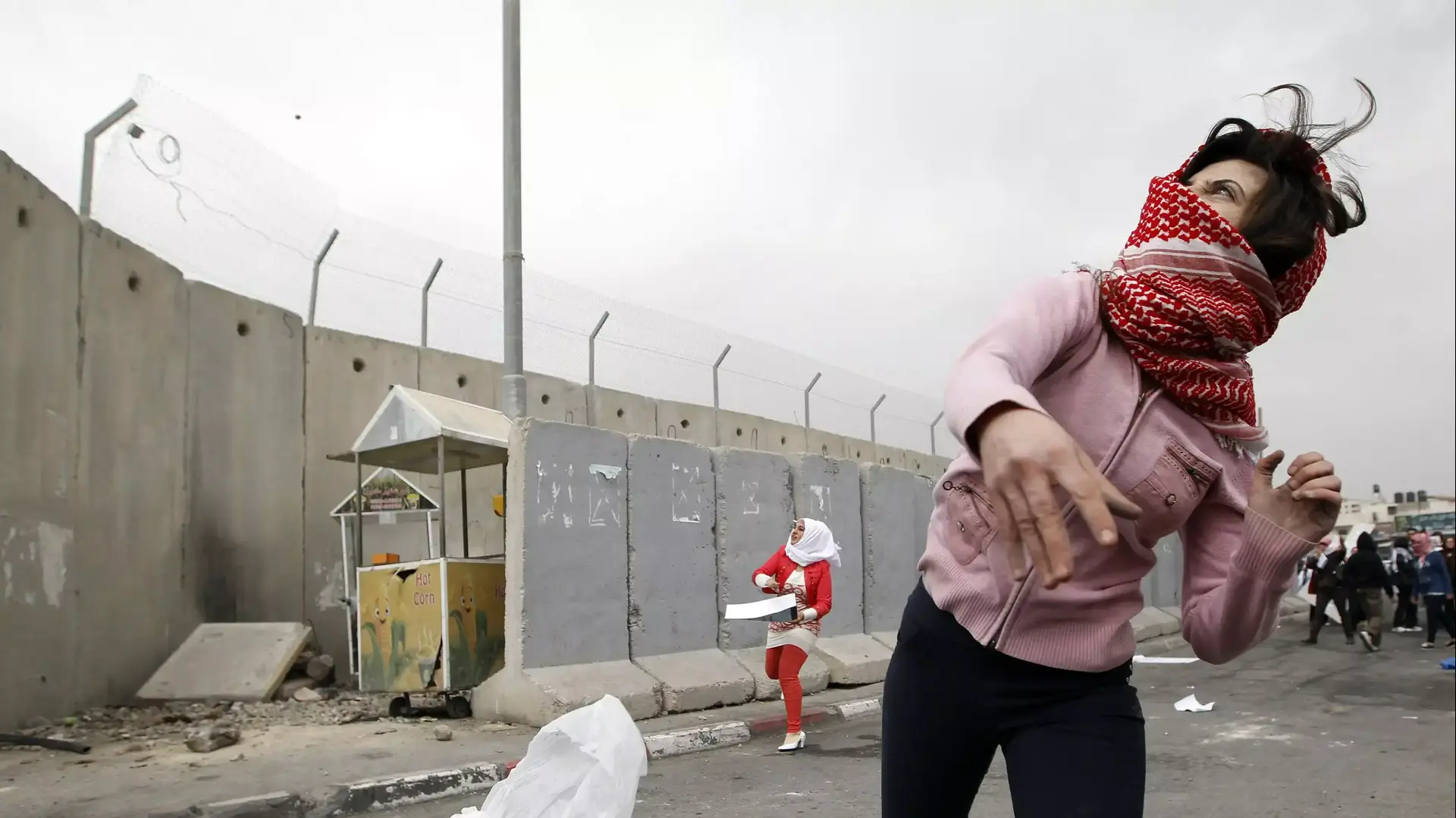 פלסטינית משליכה אבן ליד מחסום קלנדיה, 8 במרץ 2014 פלסטינית משליכה אבן ליד מחסום קלנדיה, 8 במרץ 2014