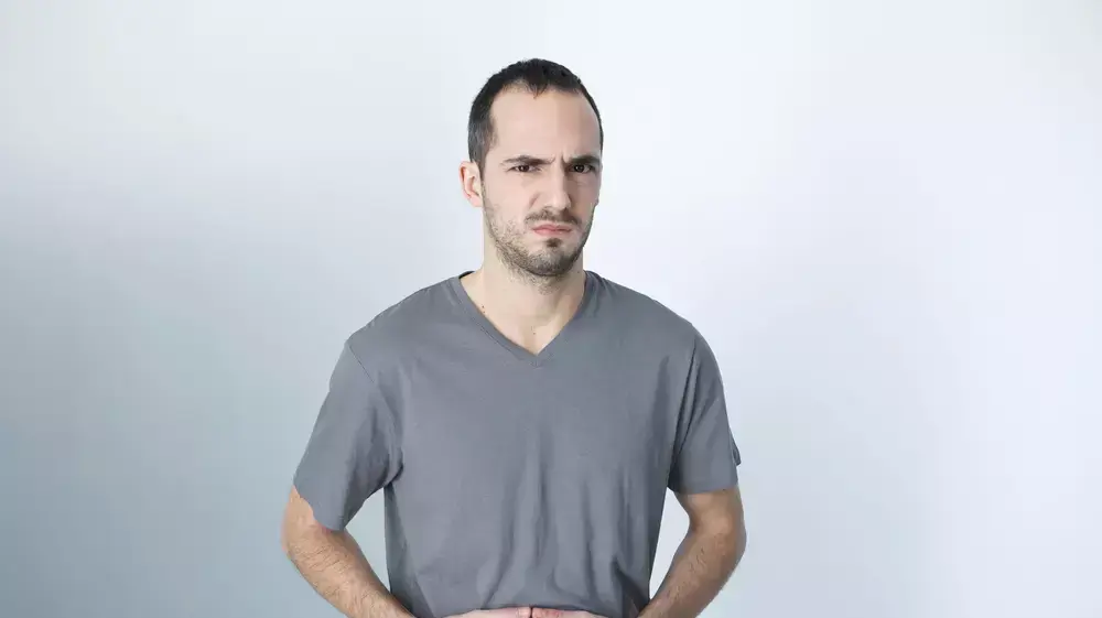 גבר מחזיק את הבטן גבר מחזיק את הבטן