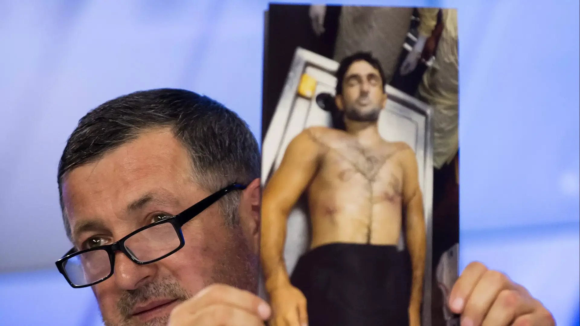 עבדול-באכי טודאשב, אביו של איברגים טודאשב, אוחז בתצלום של גופת בנו. מוסקבה, מאי 2013