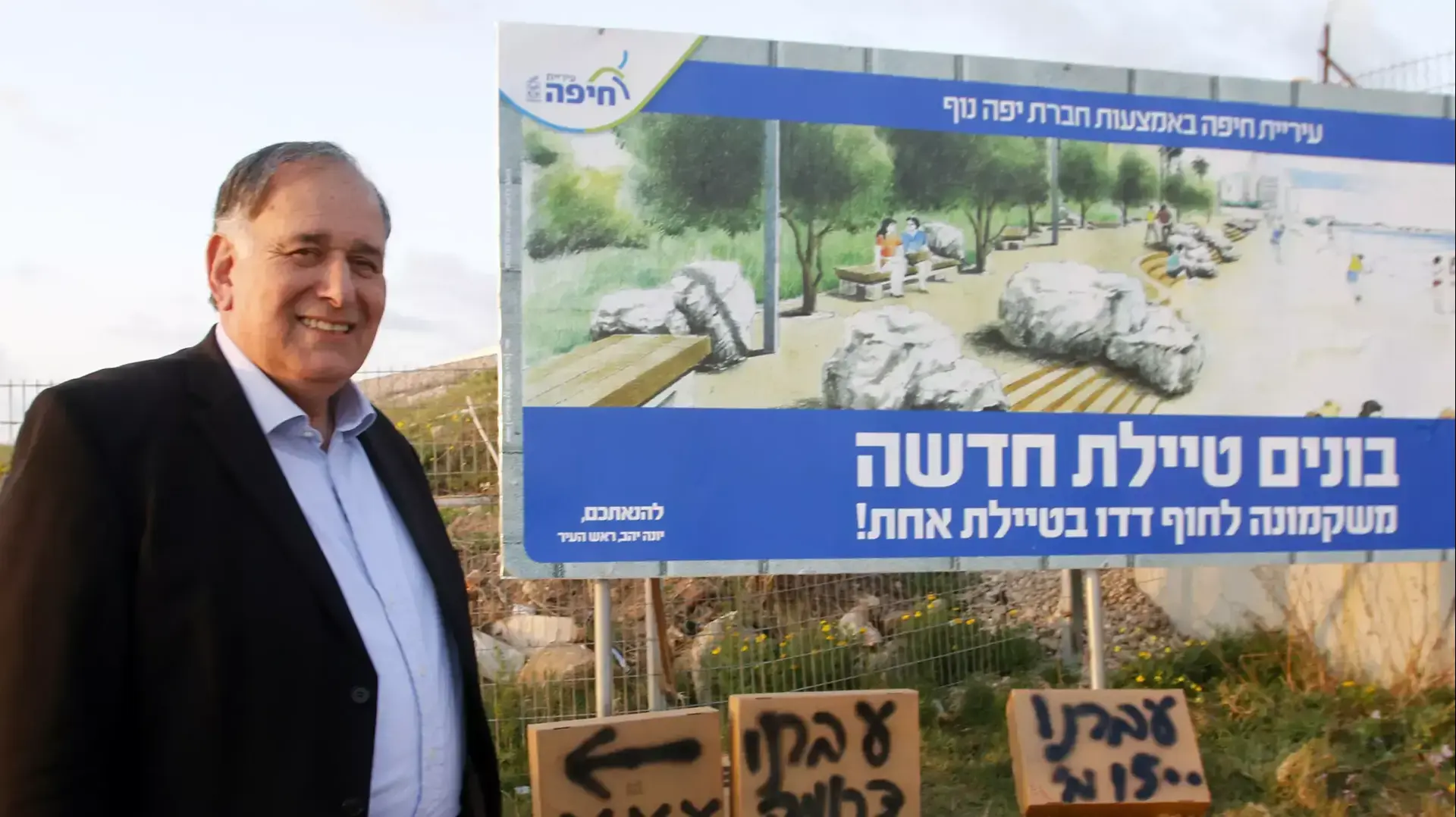 ראש עיריית חיפה, יונה יהב, עם השלטים עם הודעת המעבר של הזונות
