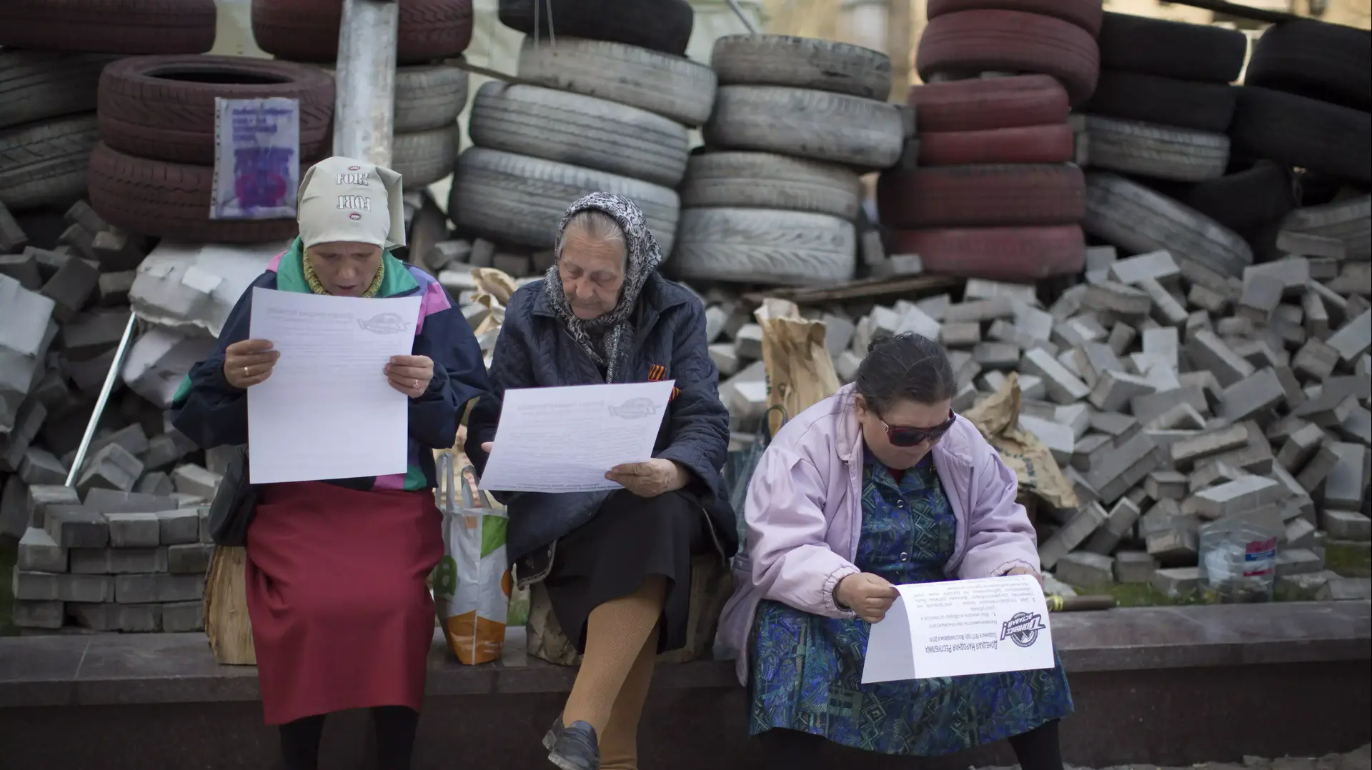 תושבות דונייצק קוראות עלונים שחילקו בדלנים רוסים שהשתלטו על בניין ממשלתי בעיר. אוקראינה, אפריל 2014