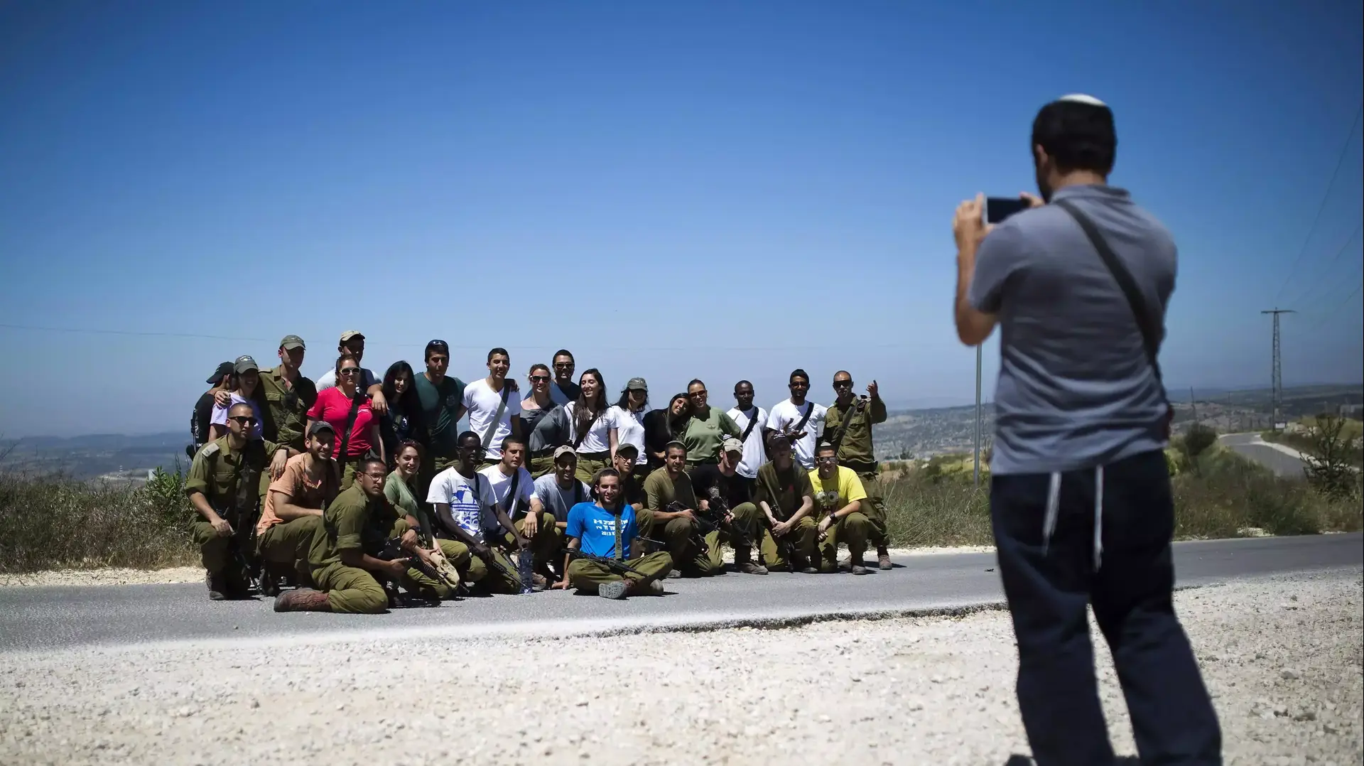 מתנחל מצלם חיילים בפאתי ההתנחלות בת עין  אפריל 2014