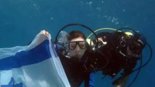 יוליה קהייקין שרעבי מצטלמת עם דגל ישראל מתחת למים. מאי 2014