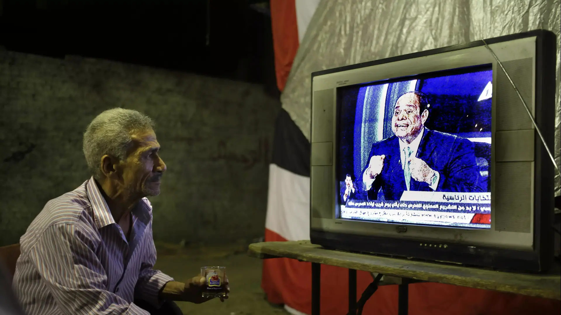 יושב בית קפה צופה בראיון של עבד אל-פתאח א-סיסי קהיר, מצרים, מאי 2014 יושב בית קפה צופה בראיון של עבד אל-פתאח א-סיסי קהיר, מצרים, מאי 2014