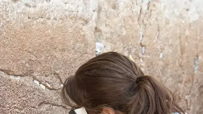אישה מתפללת בכותל