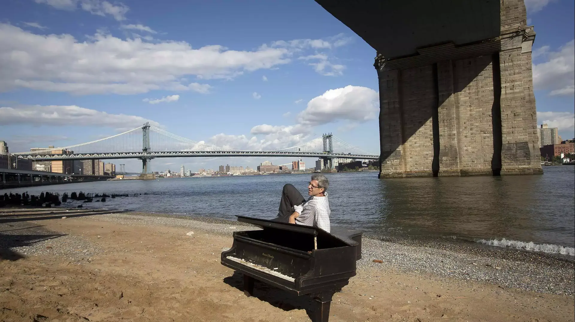 אדם מצטלם על פסנתר מתחת לגשר ברוקלין. ניו יורק, יוני 2014