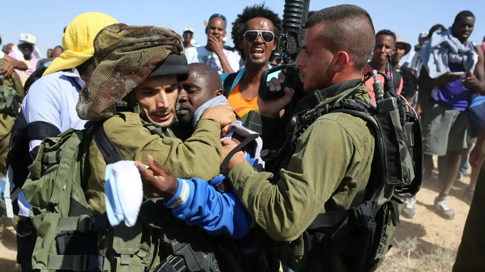 מאות מבקשי מקלט השוהים במתקן צועדים בצעדת מחאה בגבול מצרים, יוני 2014 מאות מבקשי מקלט השוהים במתקן צועדים בצעדת מחאה בגבול מצרים, יוני 2014