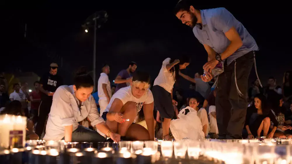 מדליקים נרות בכיכר רבין לזכר החטופים שגופותיהם נמצאו הערב. יוני 2014 מדליקים נרות בכיכר רבין לזכר החטופים שגופותיהם נמצאו הערב. יוני 2014