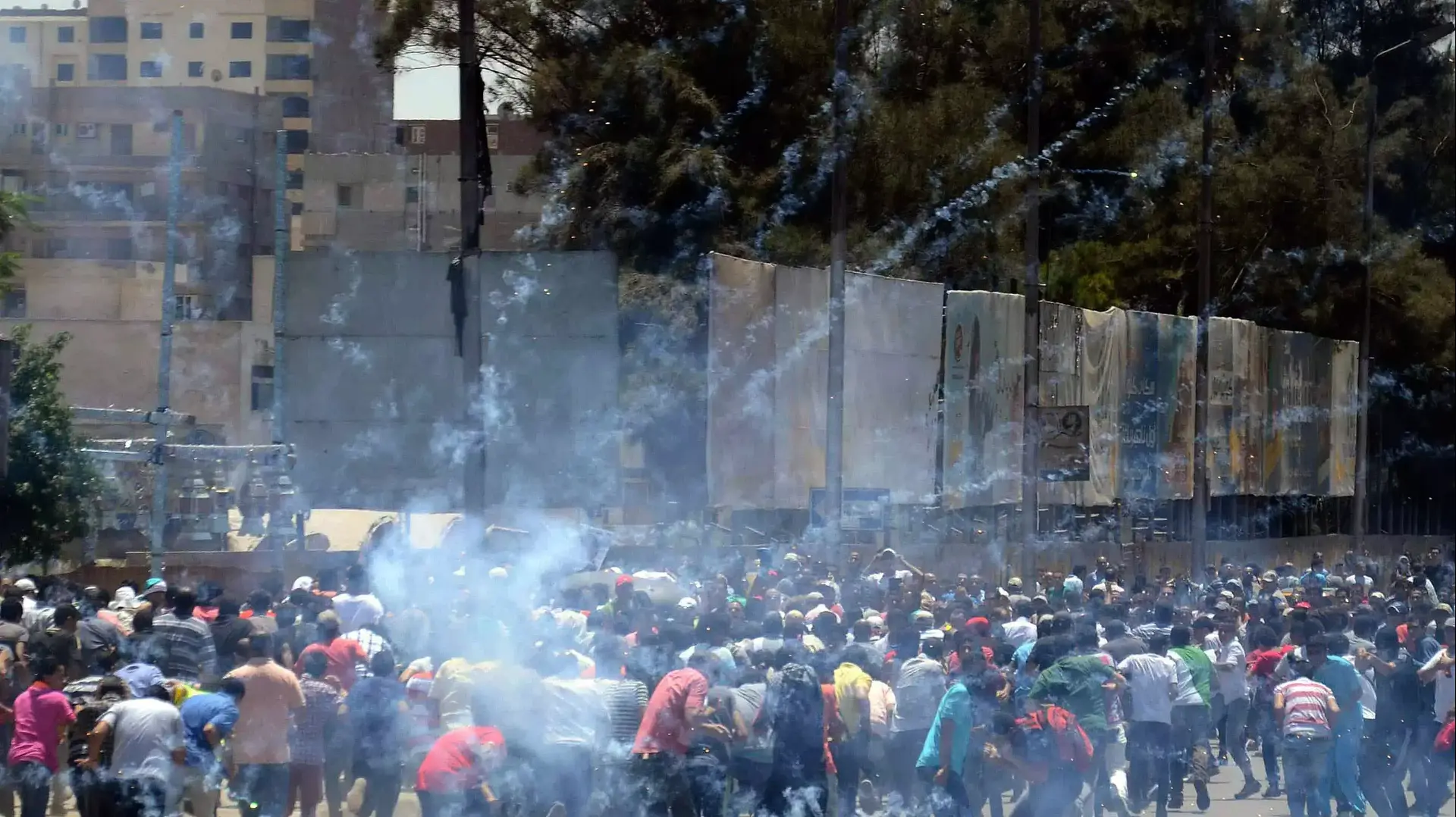תומכיו של הנשיא לשעבר של מצרים מוחמד מורסי בורחים מגז מדמיע במהלך עימותים עם המשטרה בקהיר, יולי 2014 תומכיו של הנשיא לשעבר של מצרים מוחמד מורסי בורחים מגז מדמיע במהלך עימותים עם המשטרה בקהיר, יולי 2014