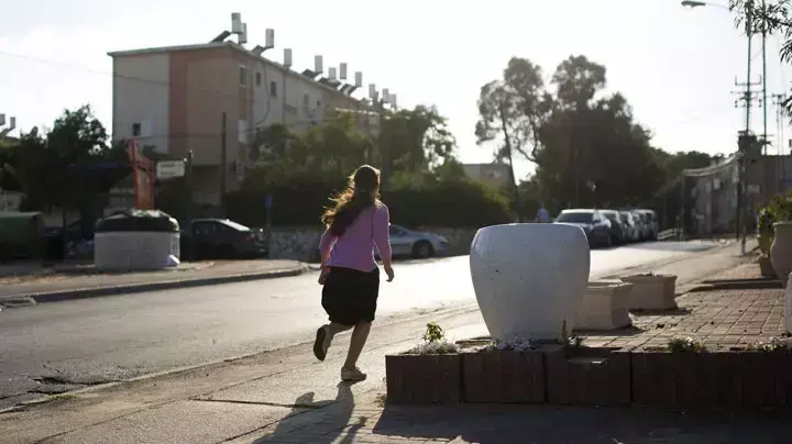 ילדה רצה למרחב המוגן בעת ירי רקטה לעבר אשקלון ילדה רצה למרחב המוגן בעת ירי רקטה לעבר אשקלון