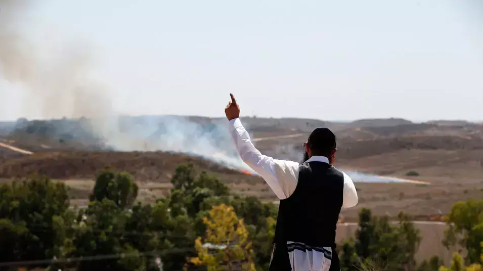 אדם ליד שריפה שנגרמה מנפילת רקטה באזור שדרות, מבצע "צוק איתן", יולי 2014 אדם ליד שריפה שנגרמה מנפילת רקטה באזור שדרות, מבצע "צוק איתן", יולי 2014