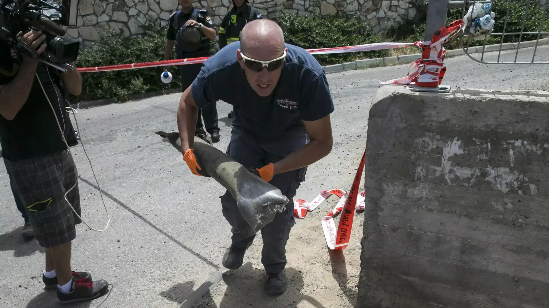 אנשי כוחות הביטחון בוחנים שרידי רקטה באשקלון, מבצע צוק איתן, יולי 2014 אנשי כוחות הביטחון בוחנים שרידי רקטה באשקלון, מבצע צוק איתן, יולי 2014