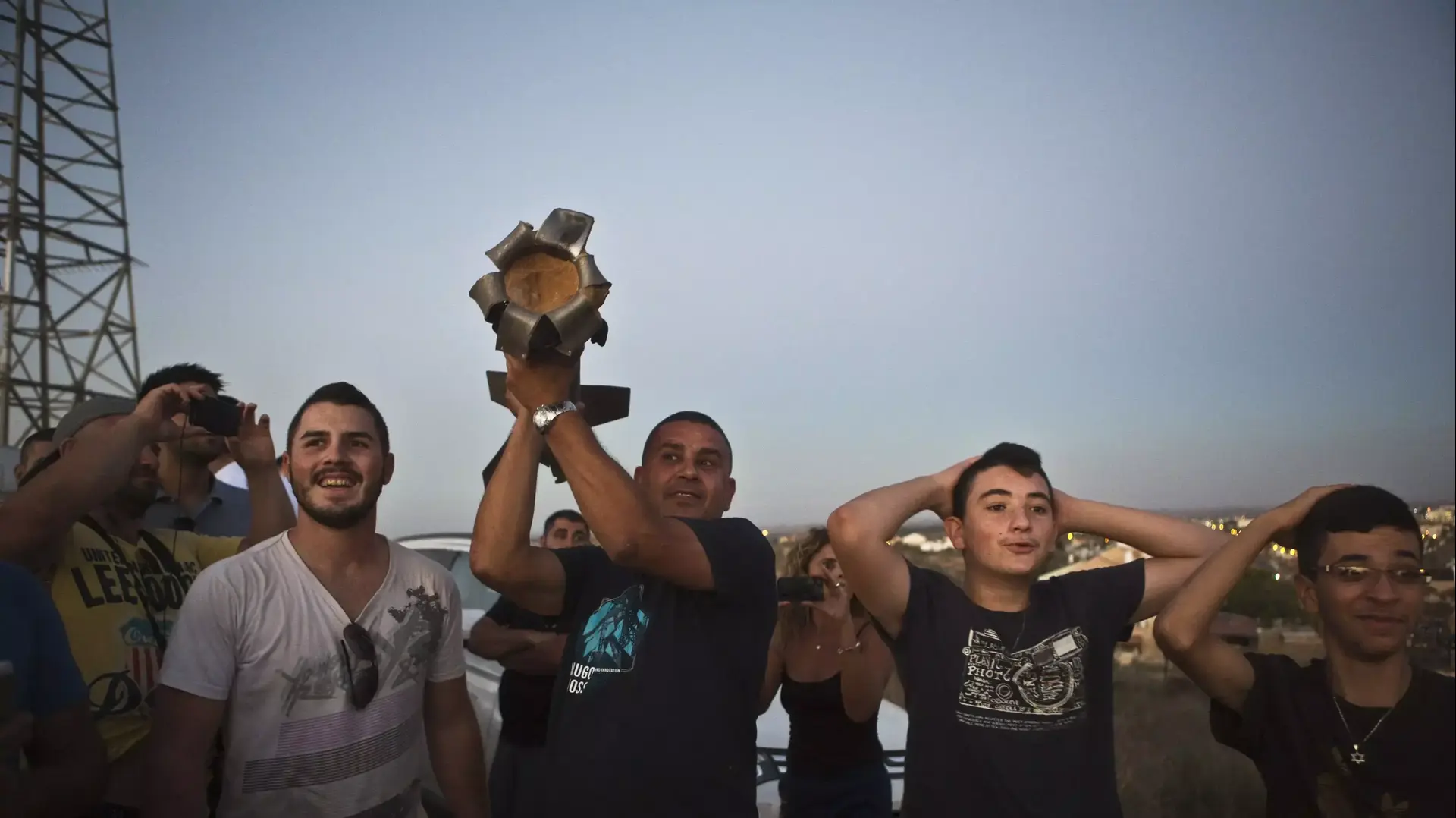 תושבי שדרות מחזיקים ברסיס רקטה שנפלה בעיר 13 ביולי 2014