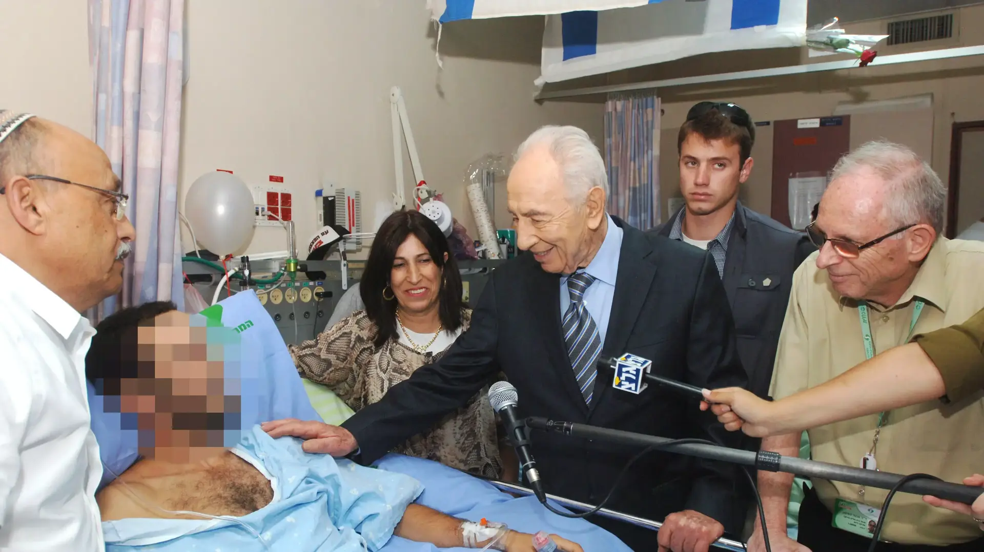 שמעון פרס בביקור חיילים פצועים בבית חולים סורוקה, יולי 2014 שמעון פרס בביקור חיילים פצועים בבית חולים סורוקה, יולי 2014