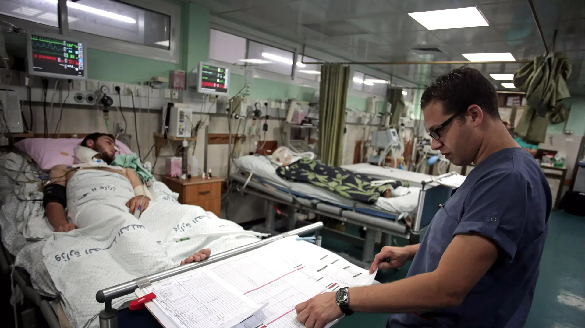 רופא ומטופלים בבית החולים שיפא בעזה, מבצע צוק איתן, יולי 2014 רופא ומטופלים בבית החולים שיפא בעזה, מבצע צוק איתן, יולי 2014
