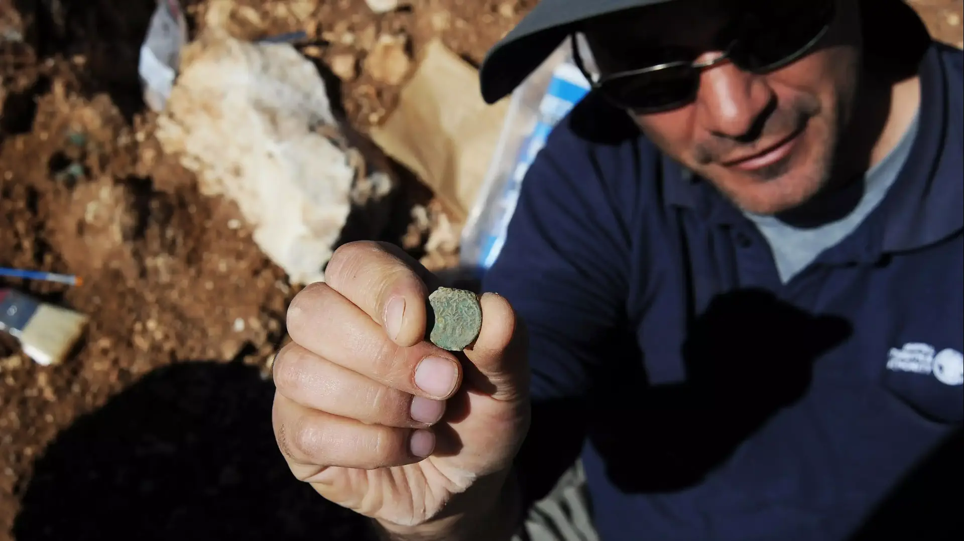 ארכיאולוג מחוז יהודה ברשות העתיקות, פבלו בצר, עם מטבע משנת 4 למרד. ארכיאולוג מחוז יהודה ברשות העתיקות, פבלו בצר, עם מטבע משנת 4 למרד.