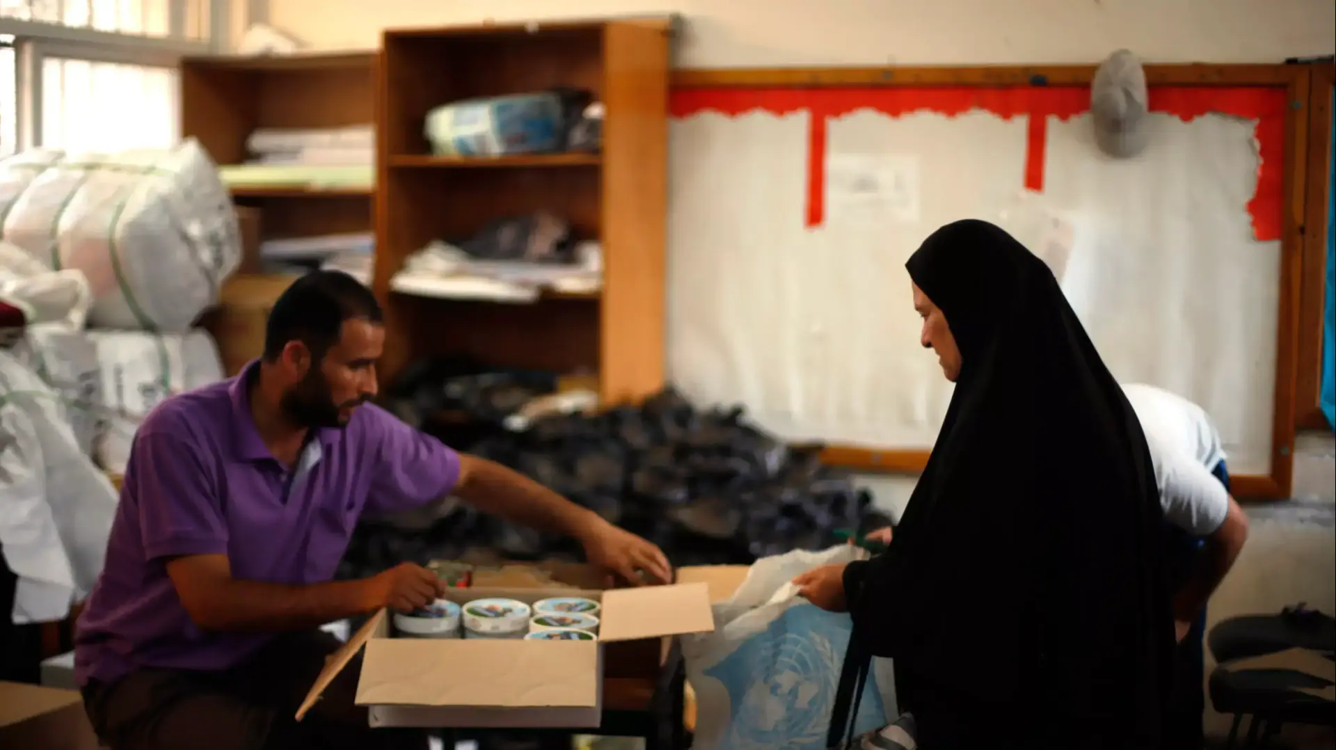 פלסטינית מקבלת מוצרי מזון בבית ספר של האו"ם בבית לאהיא. 10 באוגוסט 2014 פלסטינית מקבלת מוצרי מזון בבית ספר של האו"ם בבית לאהיא. 10 באוגוסט 2014