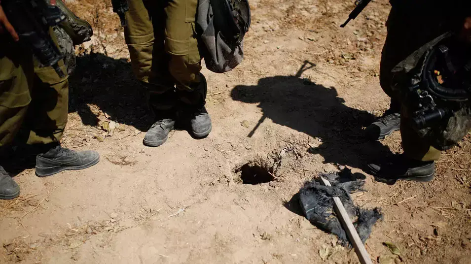חיילים עומדים ליד פתח שנחשד כפיר מנהרה מחוץ לרצועת עזה, אוגוסט 2014 חיילים עומדים ליד פתח שנחשד כפיר מנהרה מחוץ לרצועת עזה, אוגוסט 2014