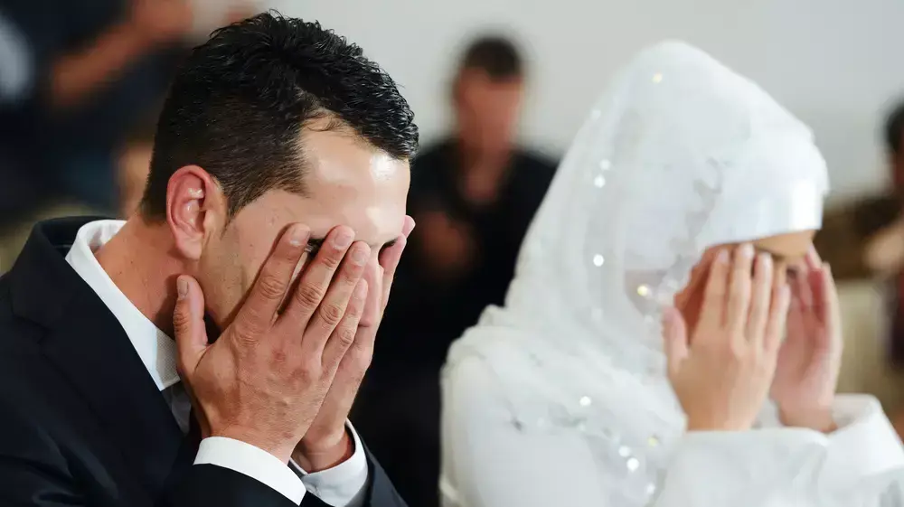 חתן וכלה מוסלמים מתפללים במסגד