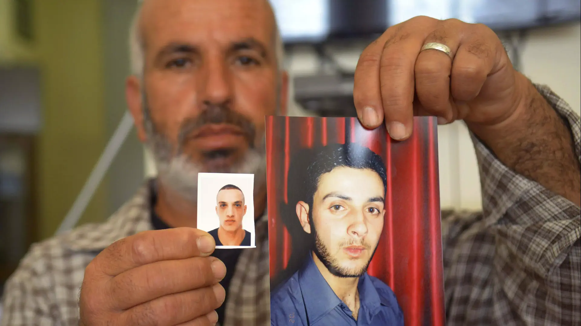 קרוב משפחה מראה את תמונותיהם של רסאן ועודאי אבו ג'מל, המחבלים שעשו את הפיגוע בבית הכנסת בהר נוף, נובמבר 2014 קרוב משפחה מראה את תמונותיהם של רסאן ועודאי אבו ג'מל, המחבלים שעשו את הפיגוע בבית הכנסת בהר נוף, נובמבר 2014