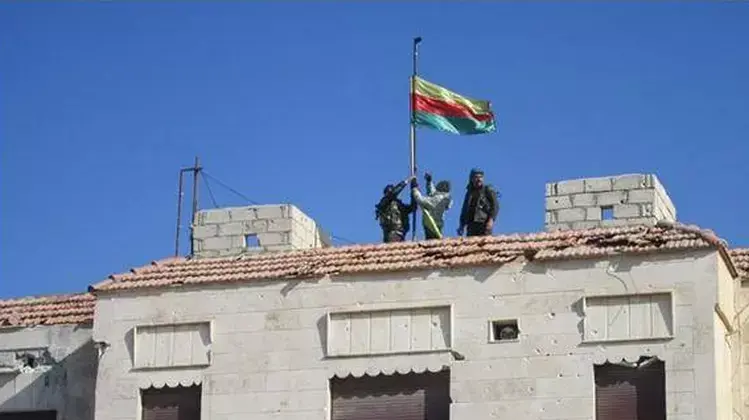 לוחמים כורדים מניפים את דגל כורדיסטן במבנה במחוז אל-חסכה, בצפון-מזרח סוריה, 17 בינואר 2015