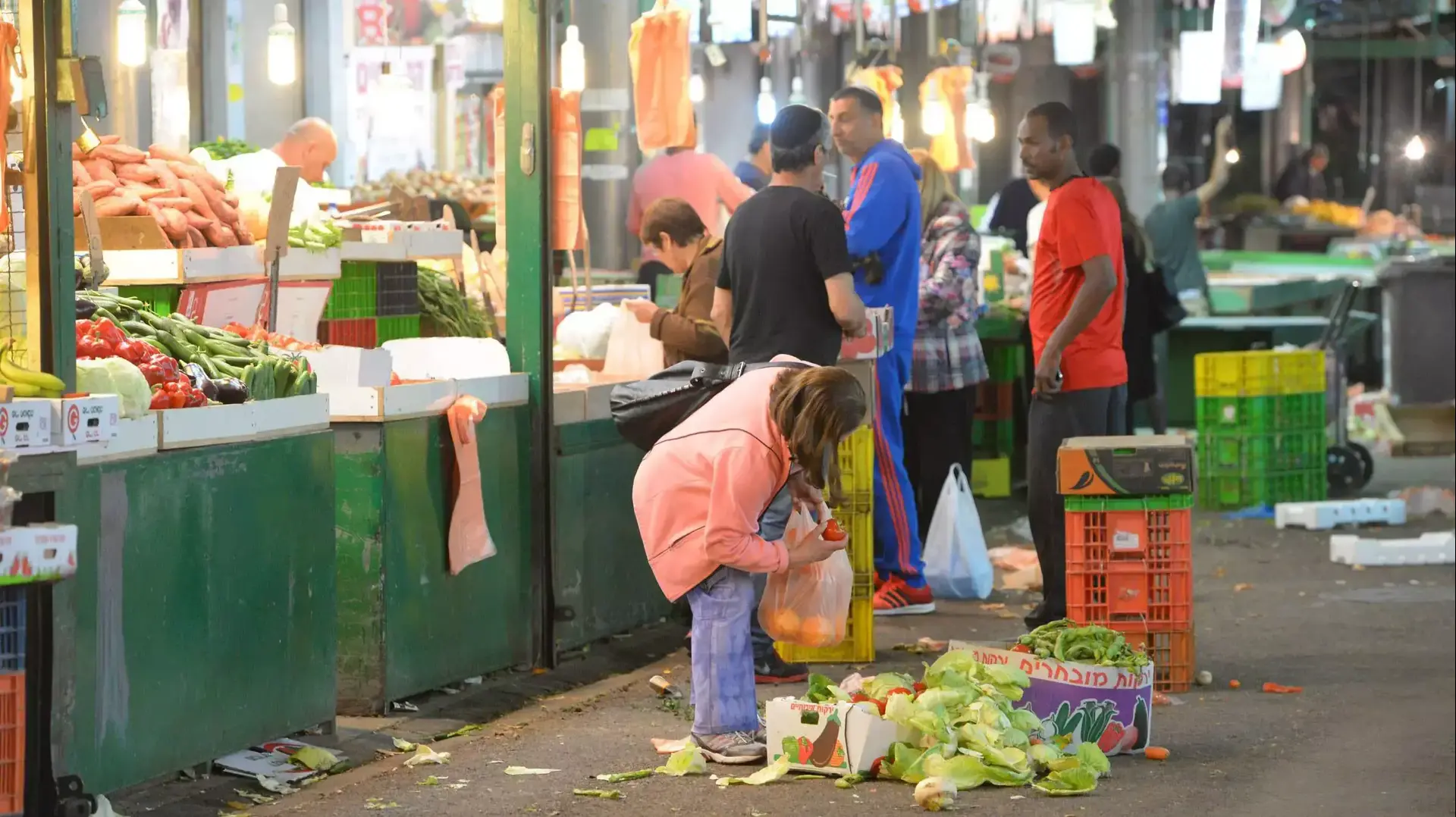 נזקקים לוקחים ירקות ופירות בשוק התקווה בתל אביב מתוך ארגזים שנזרקו, מרץ 2015