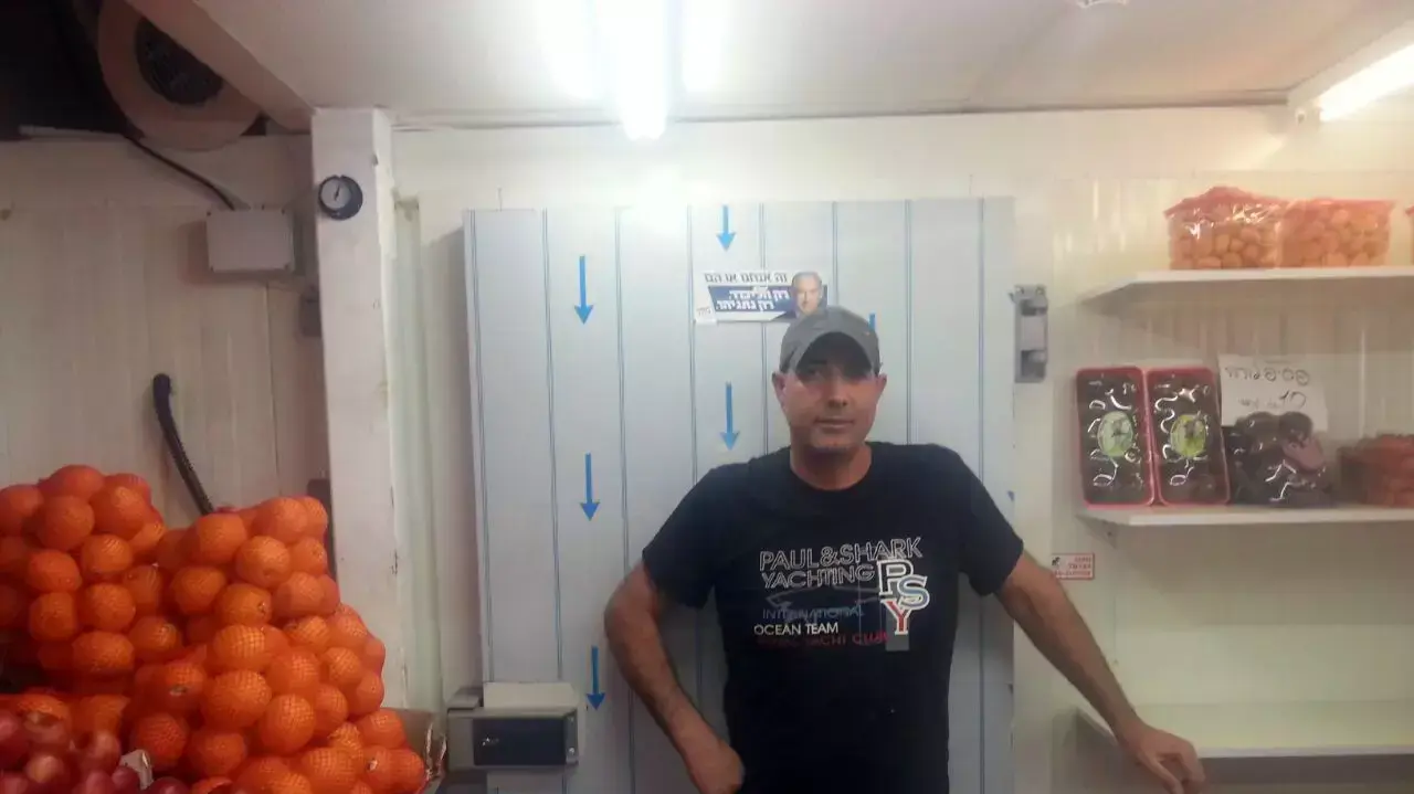 אסף אבישי העובד בדוכן כרמלה שמוכר ירקות אורגנים בשוק הכרמל אסף אבישי העובד בדוכן כרמלה שמוכר ירקות אורגנים בשוק הכרמל