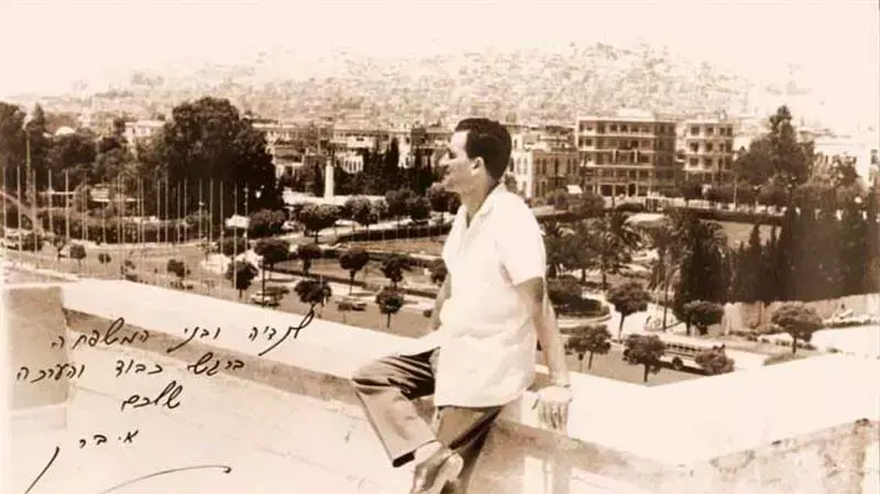 גלויה ששלח אלי כהן לבני משפחתו ע"ג תמונתו משקיף ממרפסת ביתו בדמשק גלויה ששלח אלי כהן לבני משפחתו ע"ג תמונתו משקיף ממרפסת ביתו בדמשק