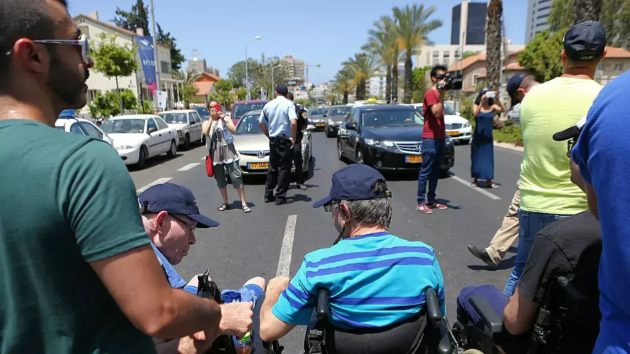 מלווי נכי צה"ל מפגינים מול הקריה על תנאי העסקתם, תל אביב, 10 ביוני 2015