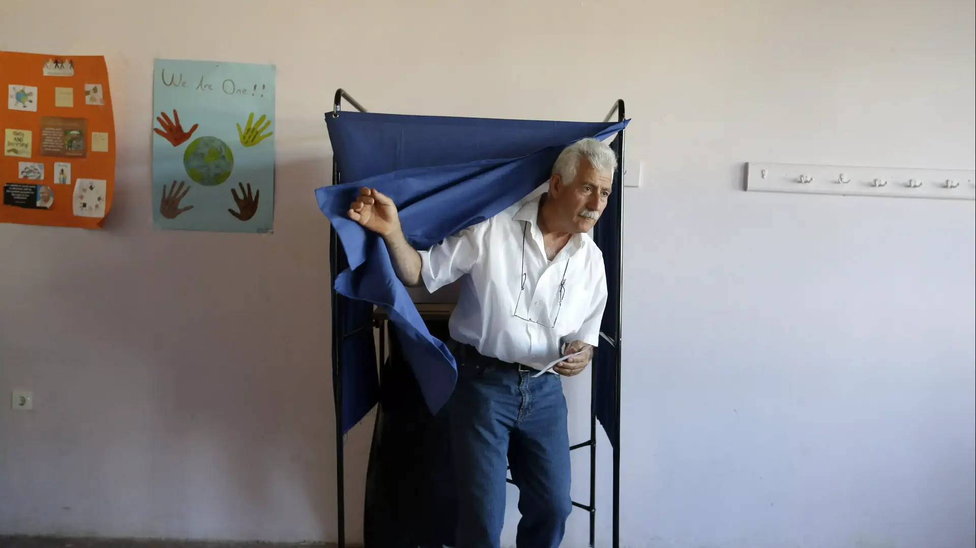 אדם מצביע למשאל העם בקלפי באתונה, יוון, 5 ביולי 2015 אדם מצביע למשאל העם בקלפי באתונה, יוון, 5 ביולי 2015
