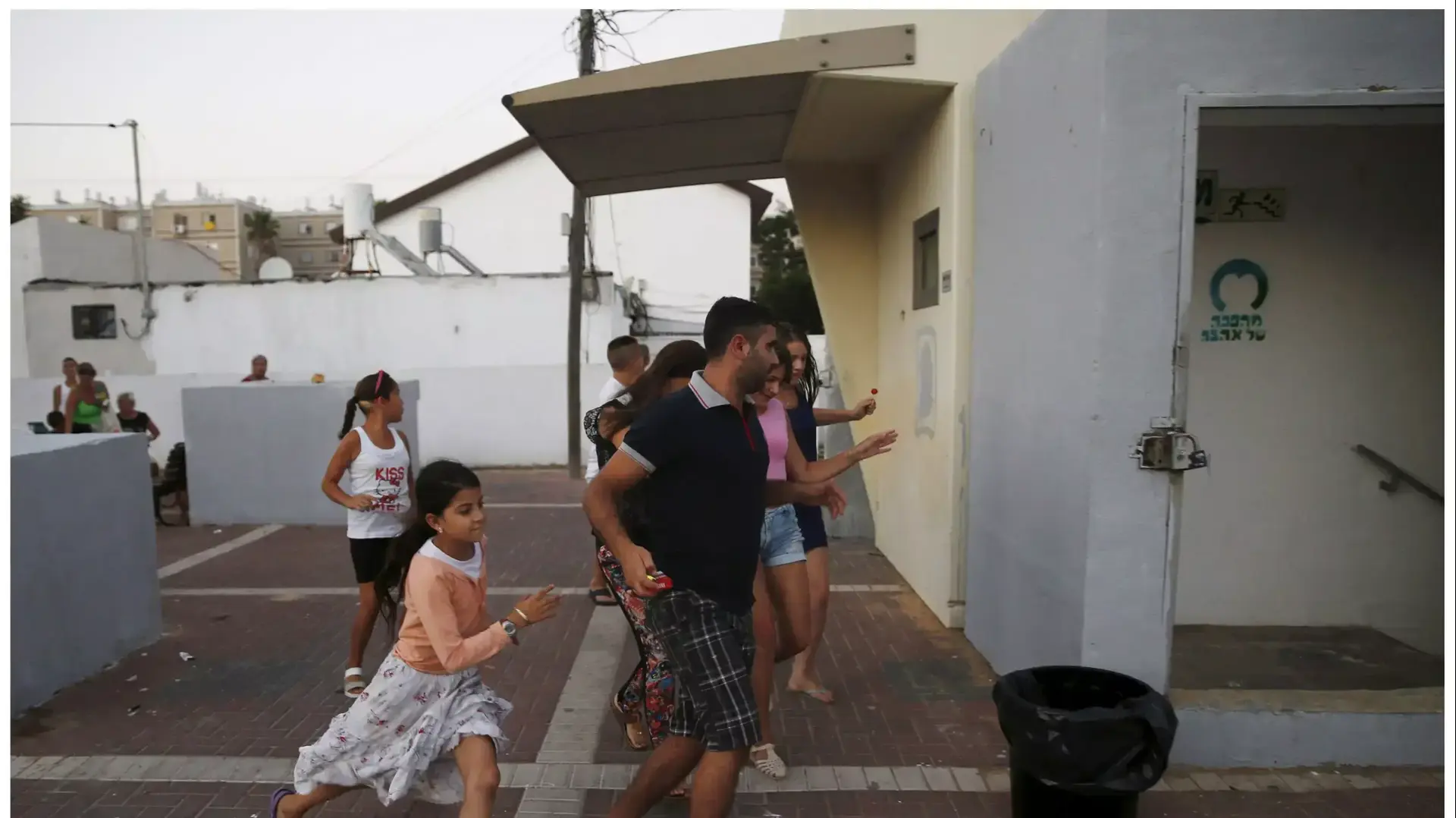 ילדים רצים למקלטים באשקלון בזמן הלחימה באוגוסט 2014 ושנה אחרי, יולי 2015