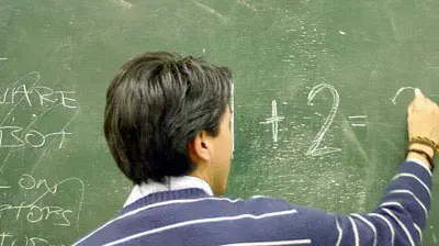 מורה כותב על לוח בכיתה