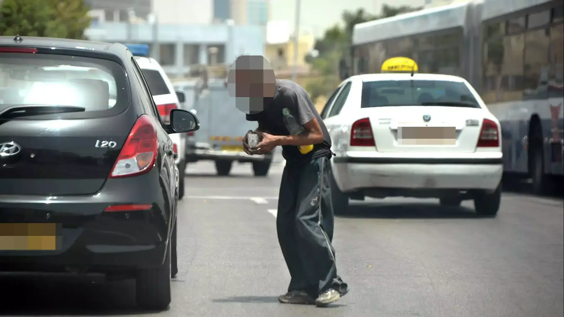 קבצן בתחנת הרכבת הישנה בעומס החום בתל אביב, מאי 2015