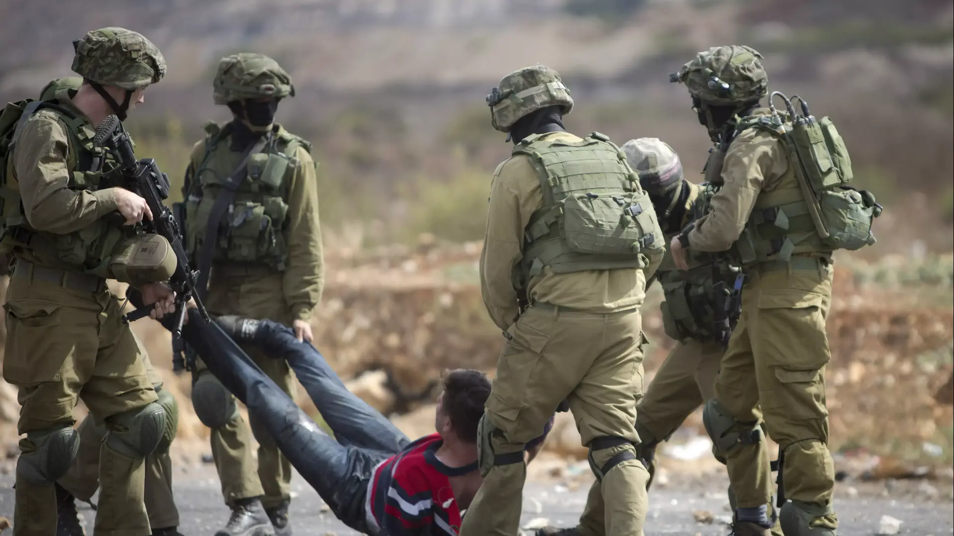 חיילים ישראלים נושאים מפגין פלסטיני שנפצע במהלך עימותים ליד רמאללה חיילים ישראלים נושאים מפגין פלסטיני שנפצע במהלך עימותים ליד רמאללה