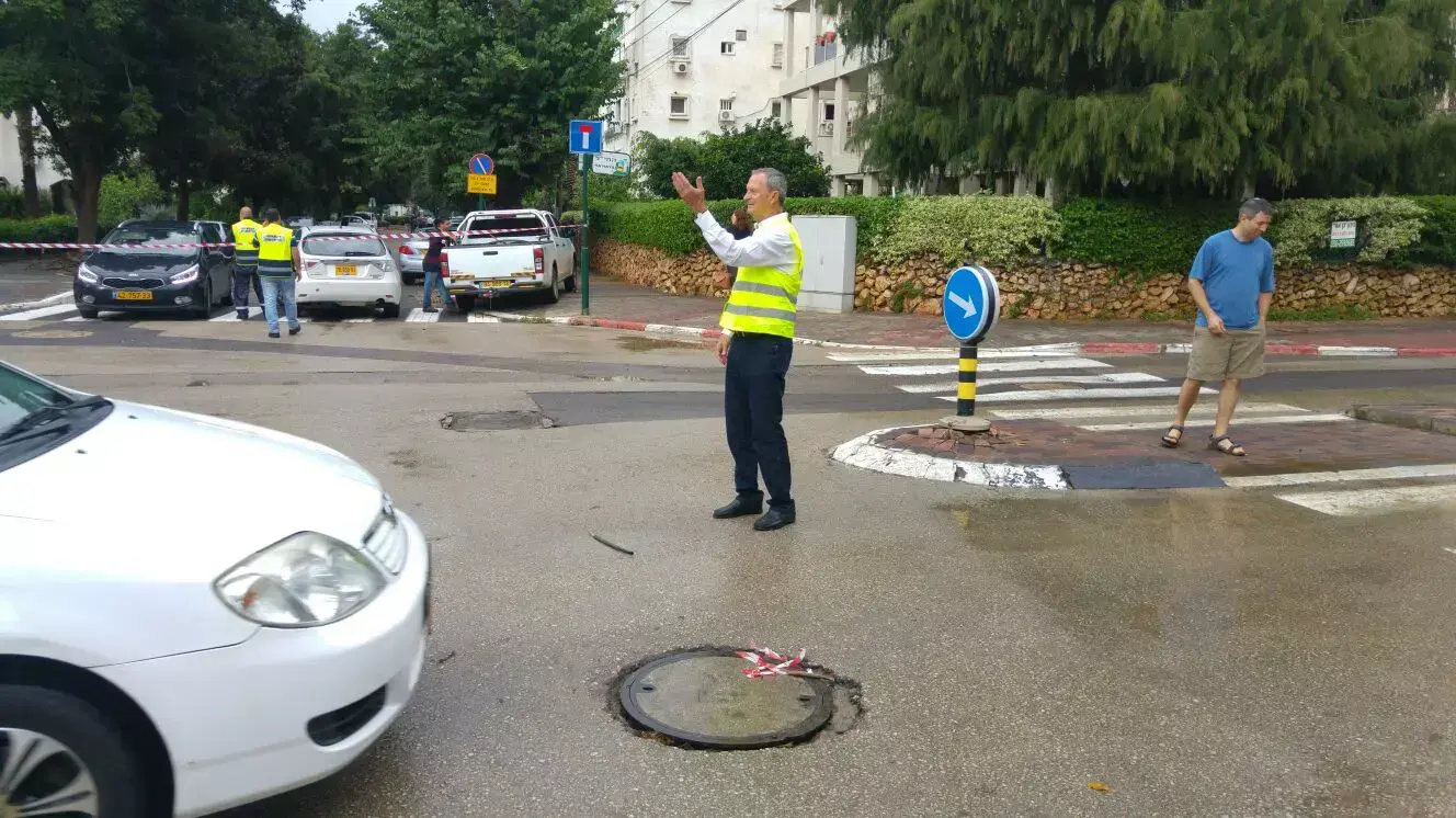 ראש עירית רעננה זאב ביילסקי מכוון תנועה ברחוב החי"ל לאחר הנזקים שגכרם הגשם במקום, אוקטובר 2015