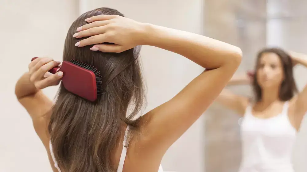 אישה מסתרקת מול המראה אישה מסתרקת מול המראה