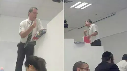 מרצה עומד על השולחן בכיתה מחולקת בין גברים לנשים בקרייה האקדמית אונו. נובמבר 2015